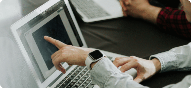 Team som samarbeider ved laptoper, symboliserer datastrøm mellom POS og ERP.